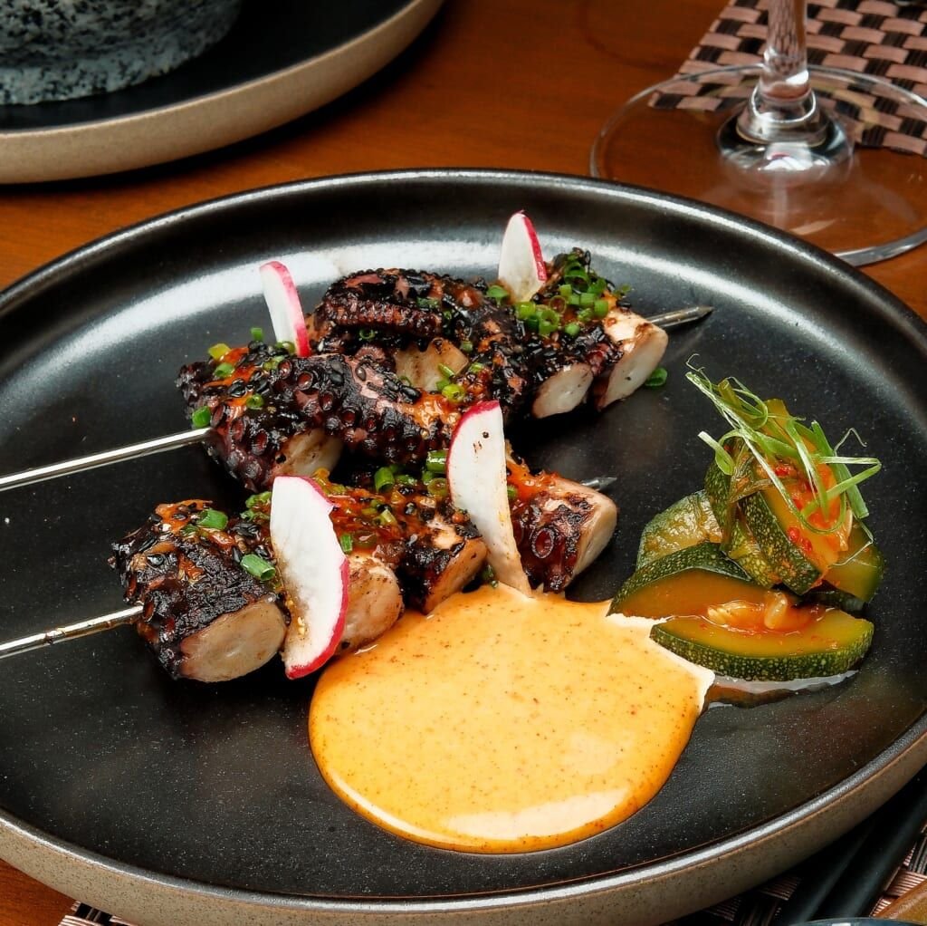 Binchotan-grilled octopus leg skewer with gochujang-honey mustard and kimchi zucchini